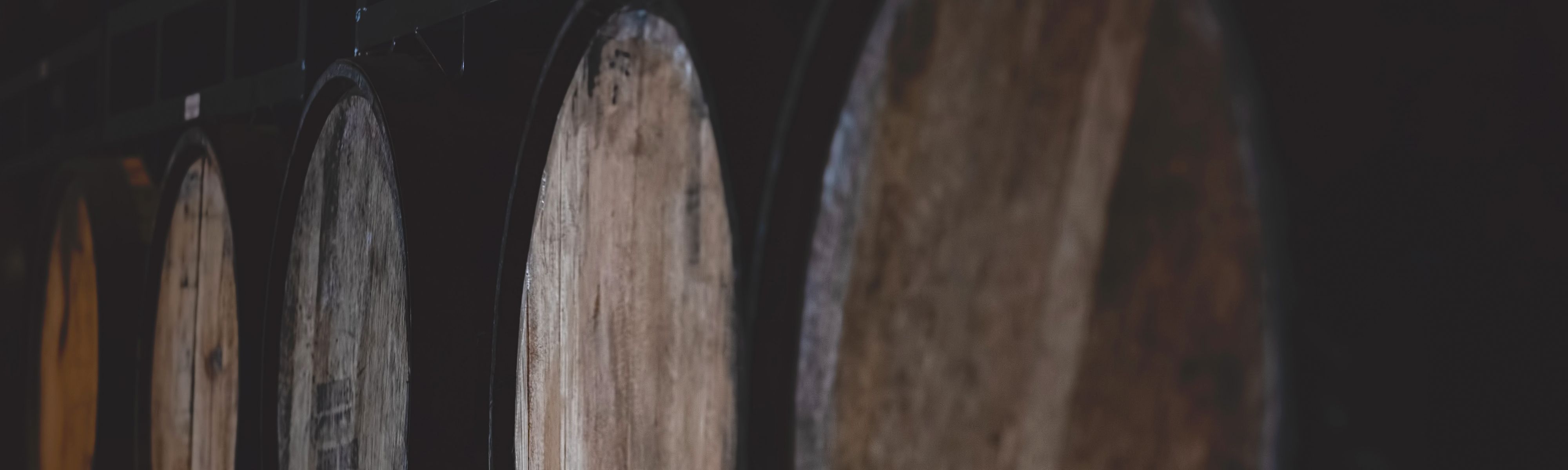 whisky barrels lined up in distillery