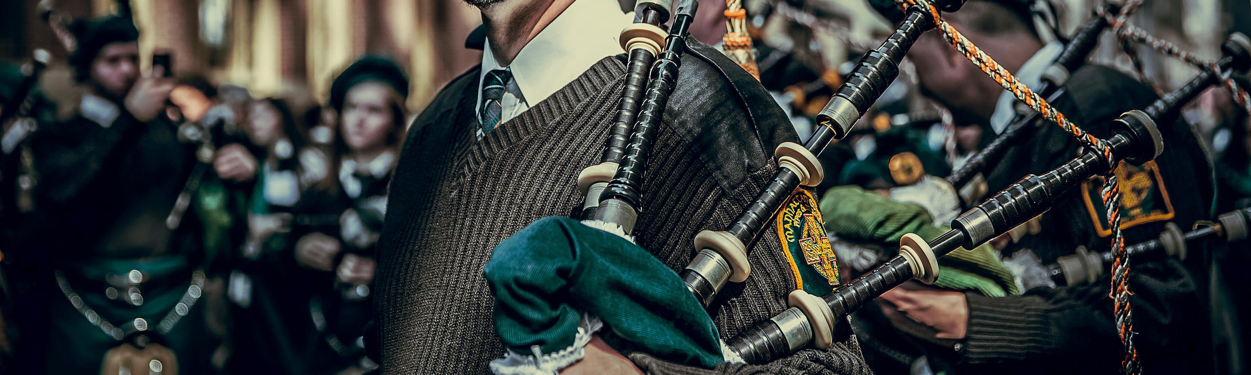 close up of irish man holding a bag pipe