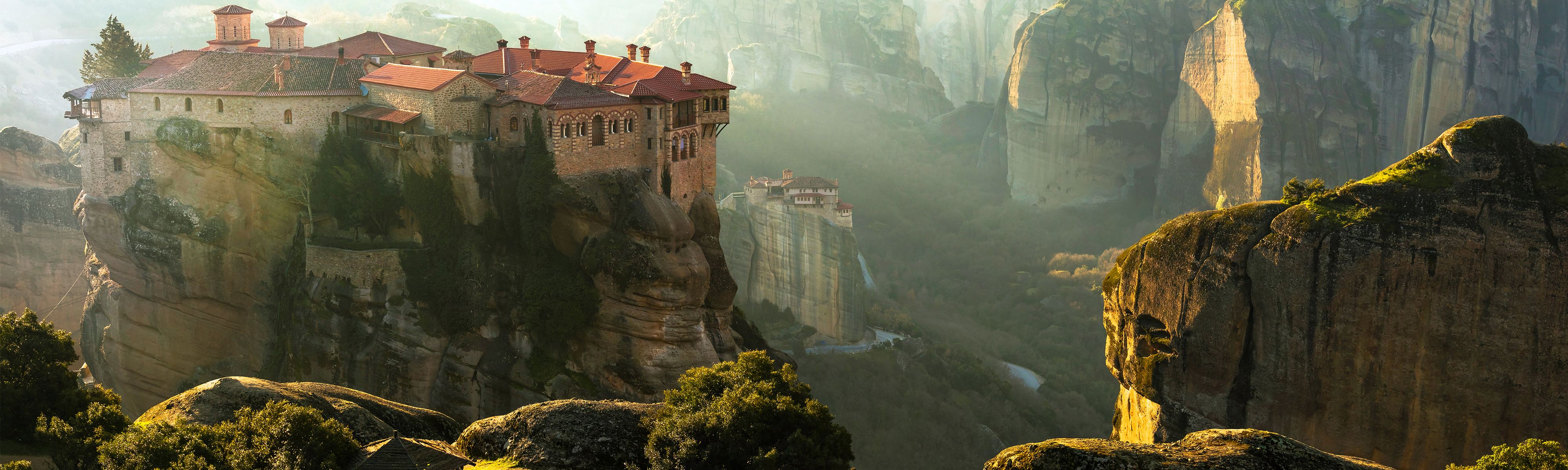 the monasteries of Meteora sitting on top of a rock cliff in Greece