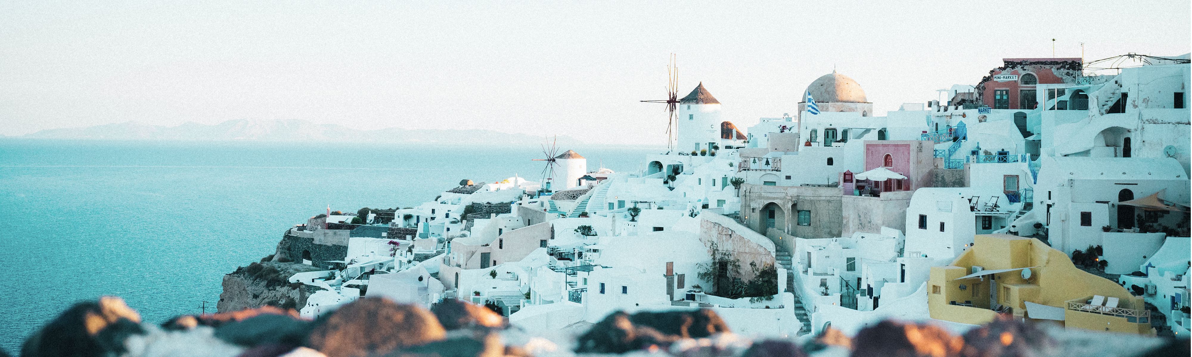 white buildings and windmills along greece's coastline