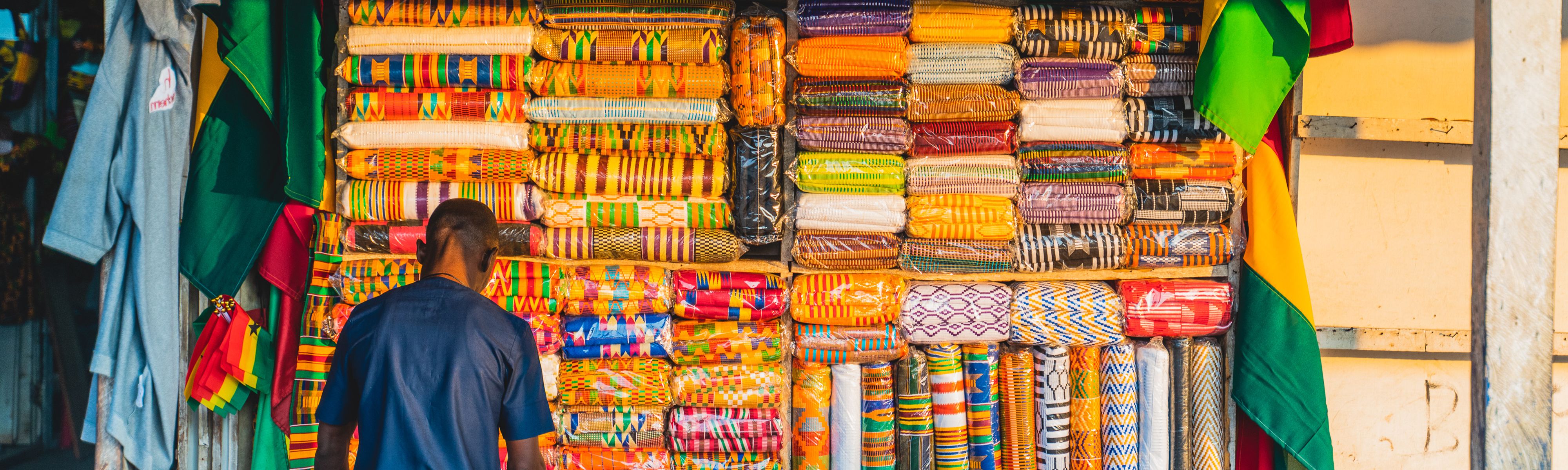 man looking at textiles at a shop in ghana