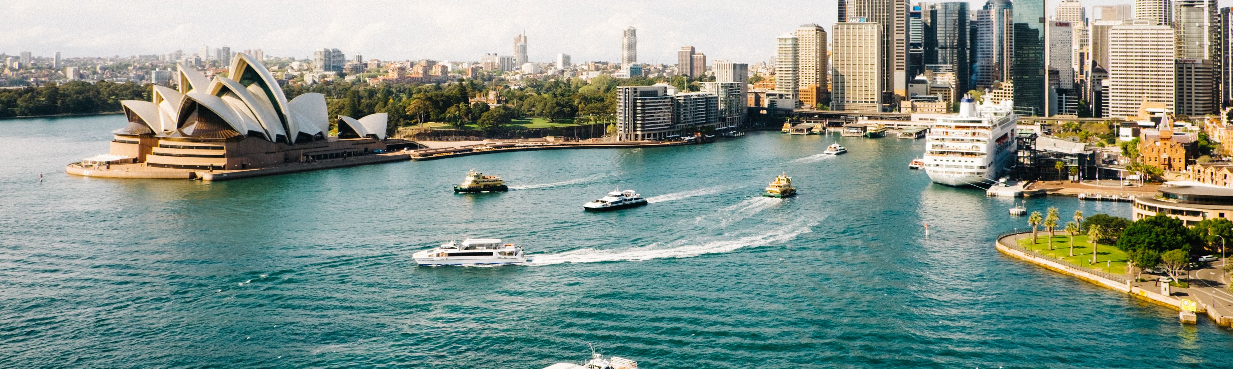 boats riding through water near opera house in sydney australia