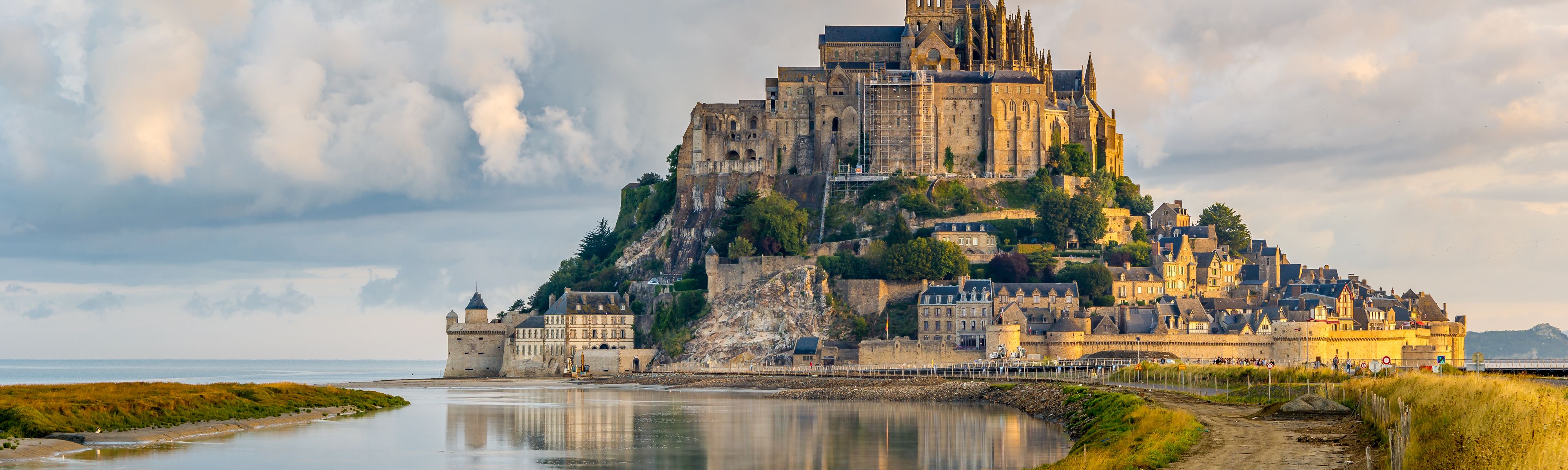 mont saint michael along the coast in france at sunset