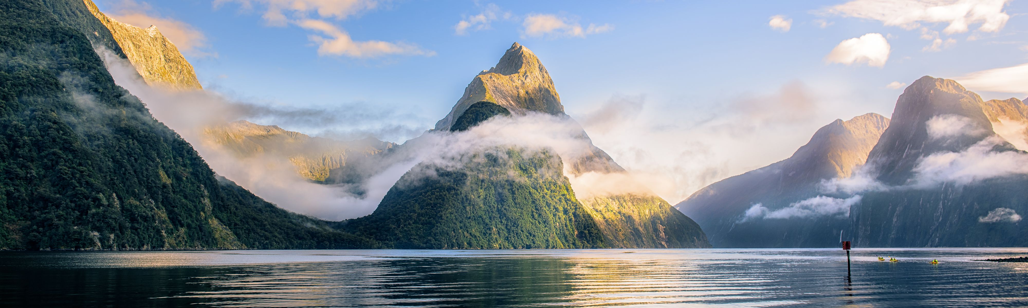 mountains in milford sound with clouds passing through