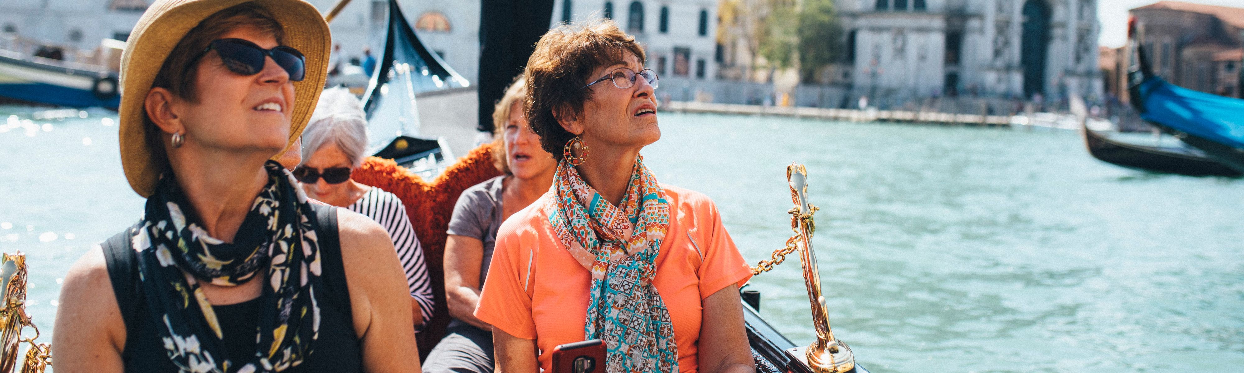 group of four women riding in a gondala in venice, italy