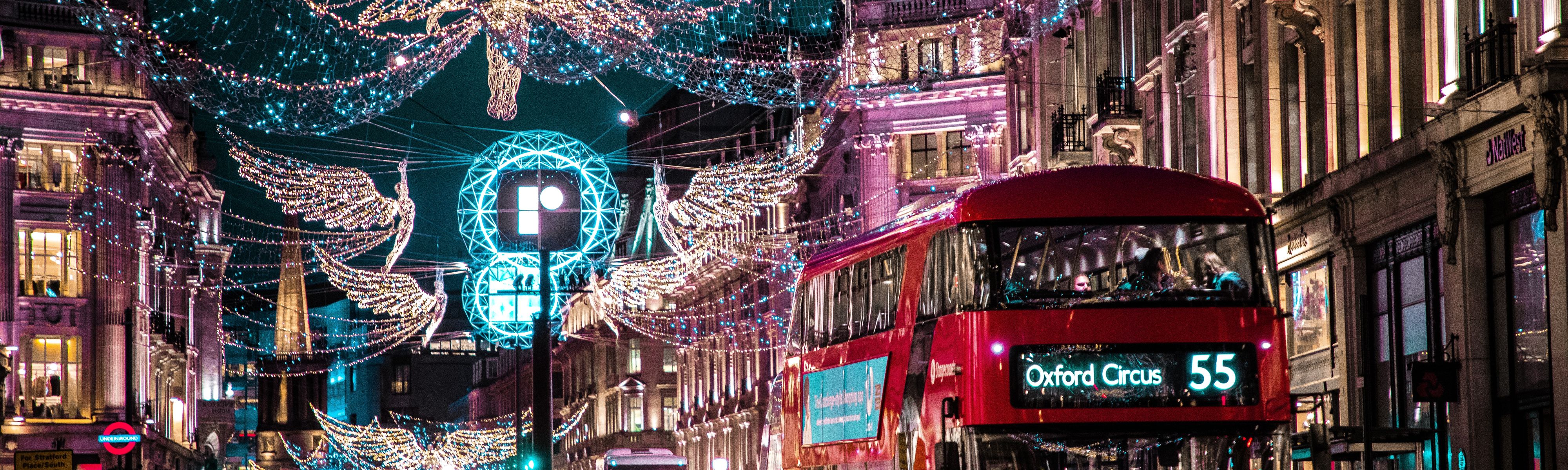 double decker bus riding through streets of london during christmas