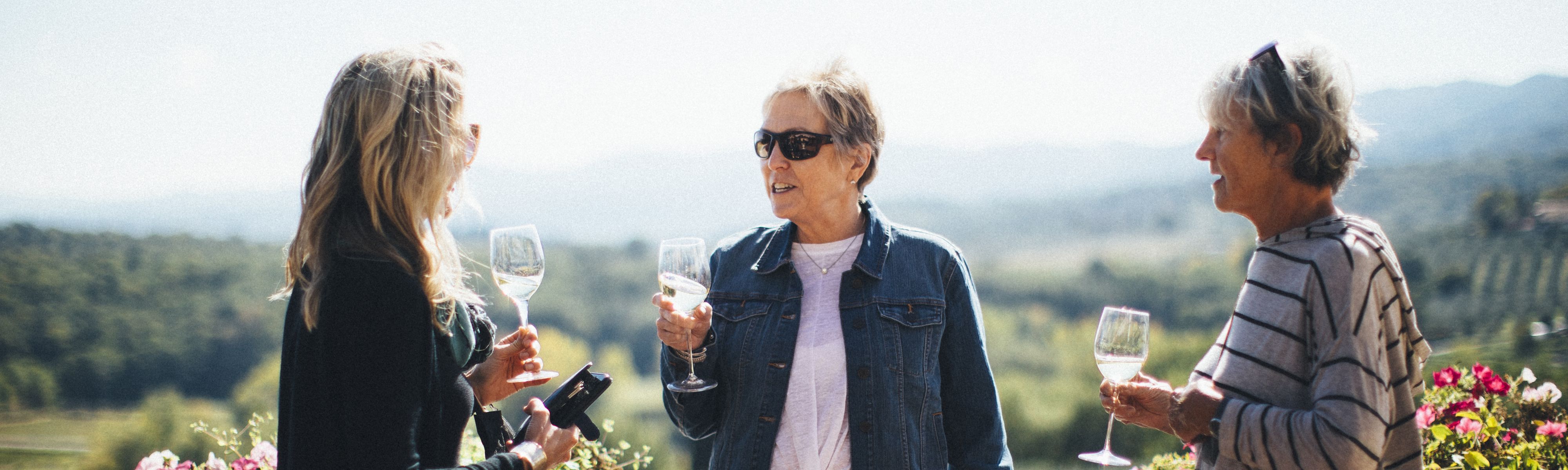 three women holding wine glasses in tuscany italy