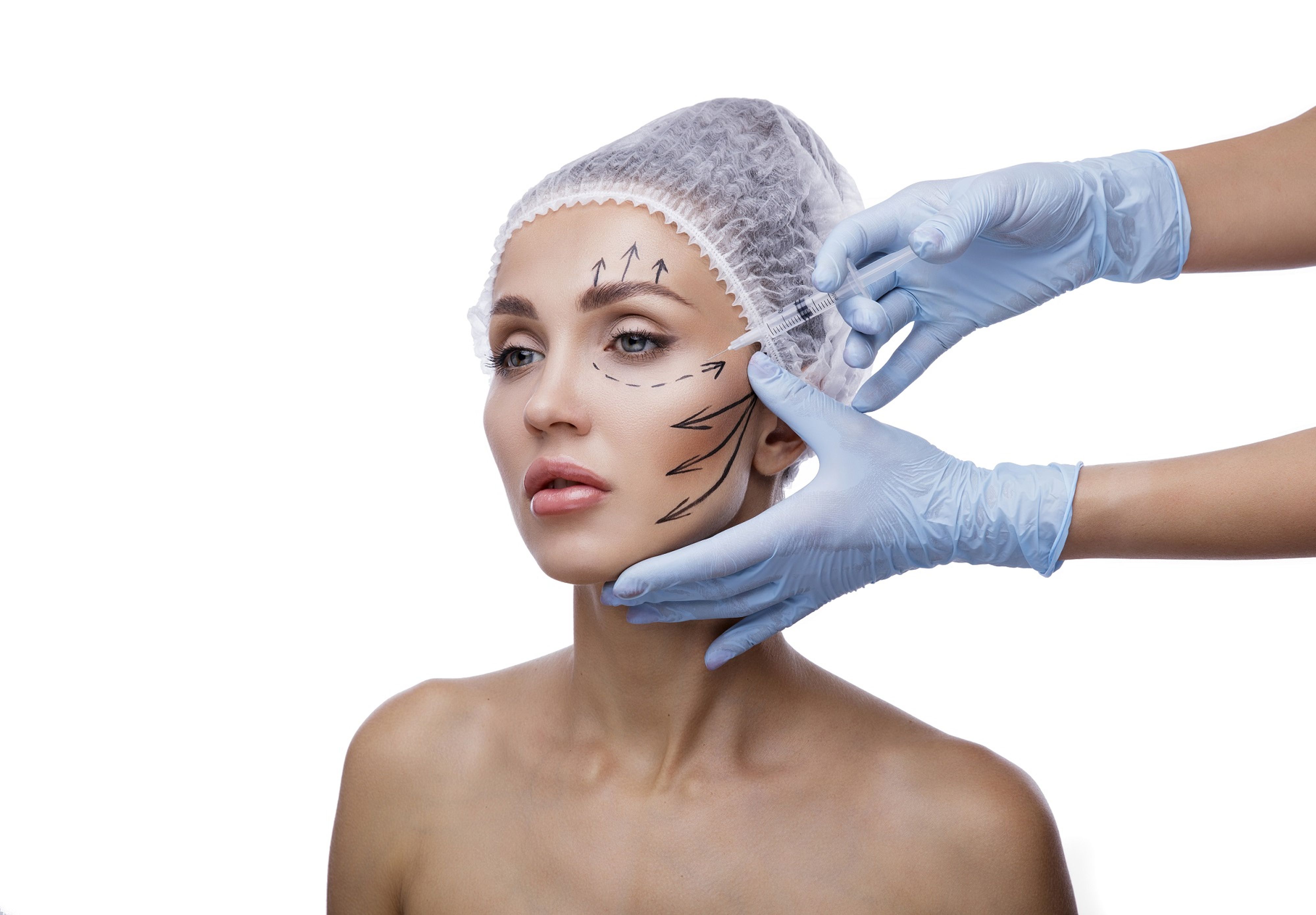 Schönheitschirurg setzt Spritze am Gesicht einer Patientin an