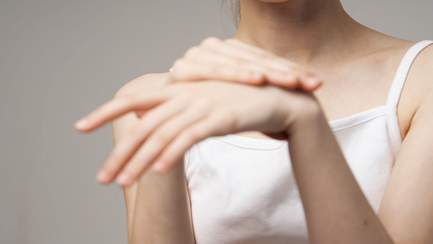 Frau umfasst mit der rechten Hand das linke, knackende Handgelenk