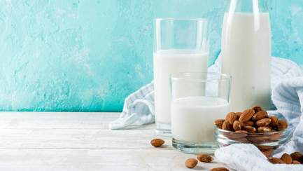 Gläser mit Milch und Nüsse als Beispiel für Calcium-Lieferanten