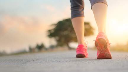 Frau joggt auf Weg - Sportverletzungen beim laufen vermeiden