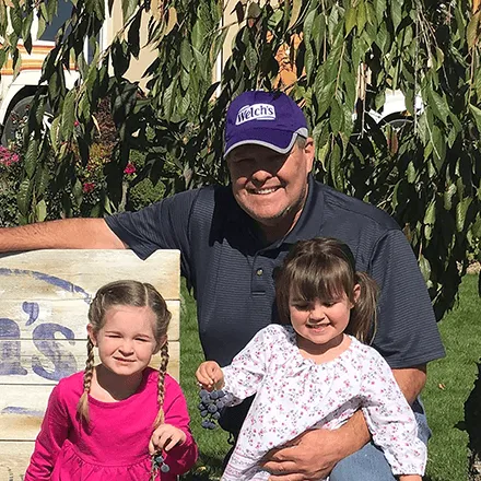 Tim Grow, Welch's Farmer, and his two granddaughters on their farm.