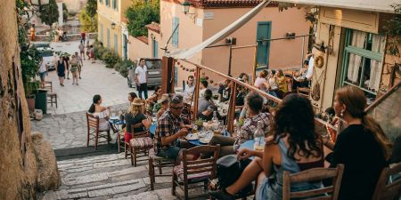 A charming streetside cafe in Athens, Greece with people eating and drinking.