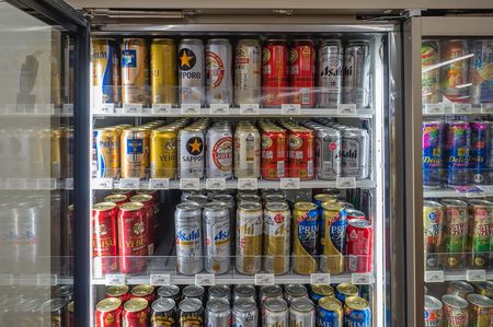 A fridge of various Japanese beer cans.