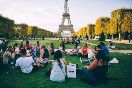 A group of people having a picnic in front of the Eiffel Tower in Paris.