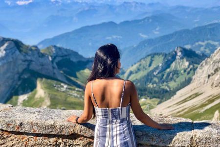 A girl gazing at a mountain range in the distance.