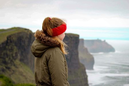 Girl standing at the Cliffs of Moher in Ireland