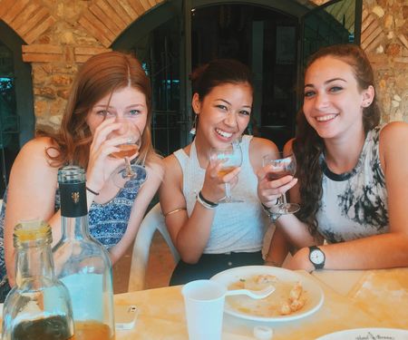 Three women enjoying glasses of wine at a restaurant in Rome.