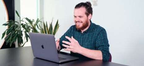 Smiling guy sitting in front of laptop