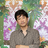 Tomokazu Matsuyama standing against a bright patterned painting