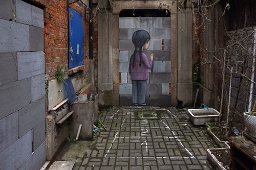 Artwork on a wall outside, a child facing the wall