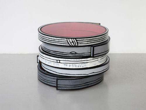Circular sculptures stacked, presented in a gallery