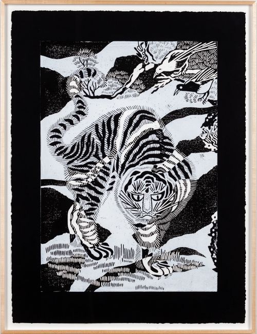 black and white tiger against a flat background with birds in the trees above