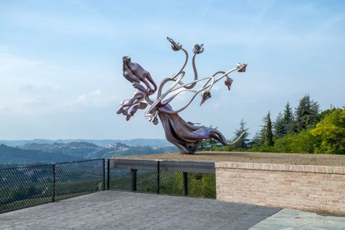 a large sculpture placed outdoors overlooking a vast landscape