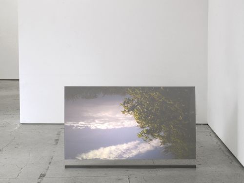 rectangular video projection of a cloudy sky set in a white exhibition space
