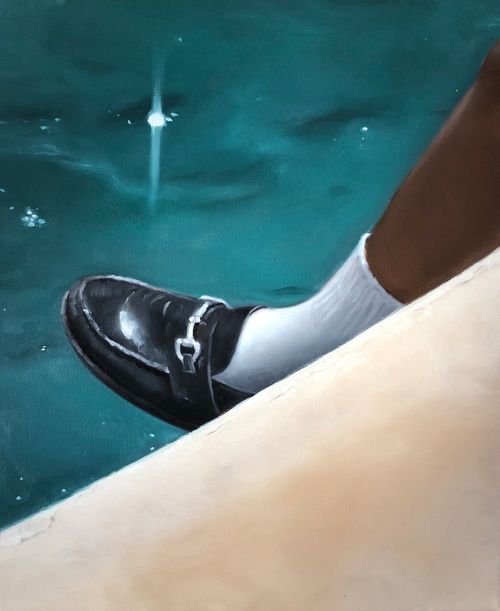 close-up of a girl's black shiny loafer with silver buckle and a white sock covering her ankle as her foot hangs in the air above a body of water