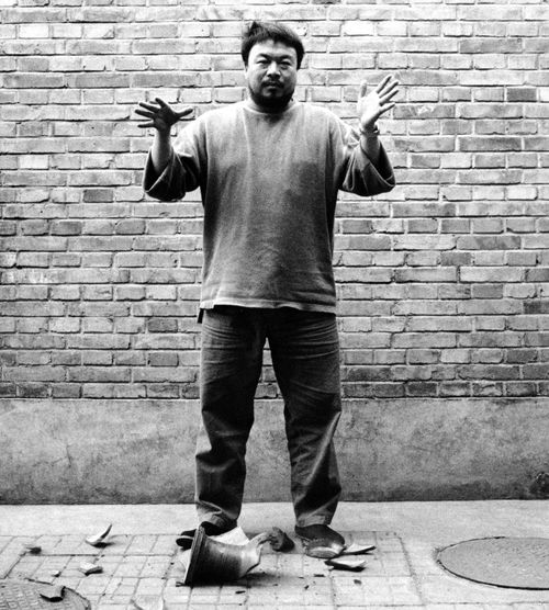 black and white photograph of Ai Weiwei casually dropping a Han Dynast Urn