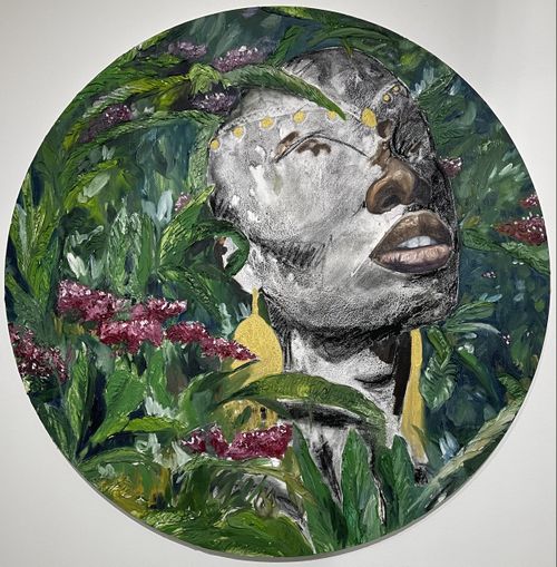 tondo of a face with eyes missing, visible through flowers and green foliage