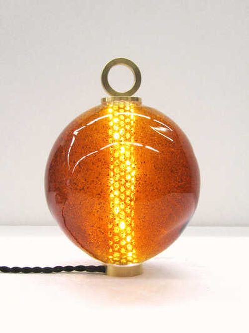 Amber coloured circular lamp emitting light from a vertical pillar in its centre