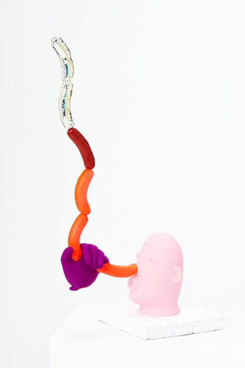 pink sculpted head with a purple hand that's holding up a line of balloon sausages reaching upwards from its nose