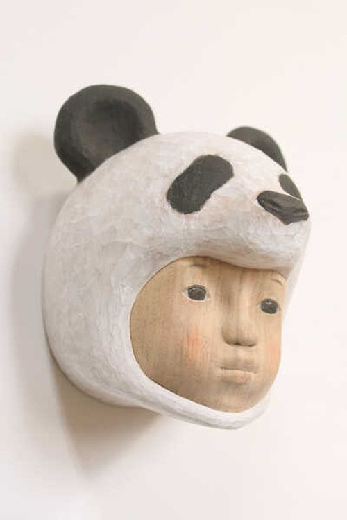 the head of a panda with a human face sticking out of a wall