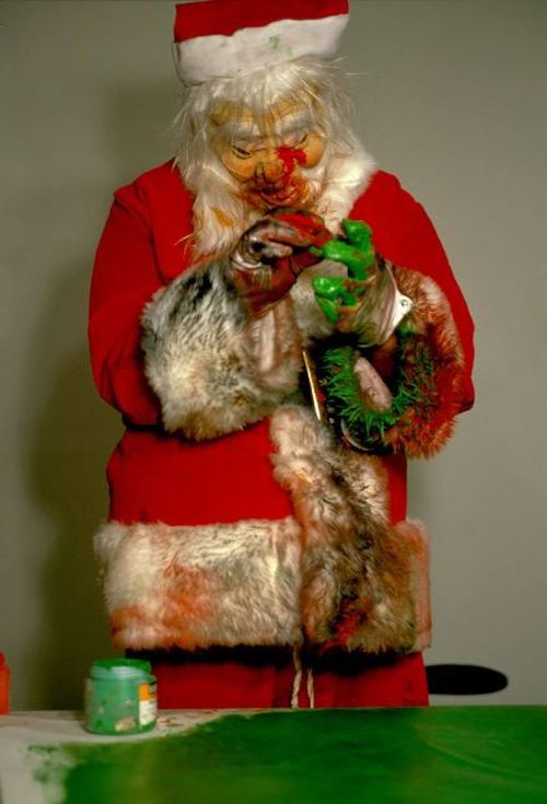 dirty Santa with gloved hands covered in green paint