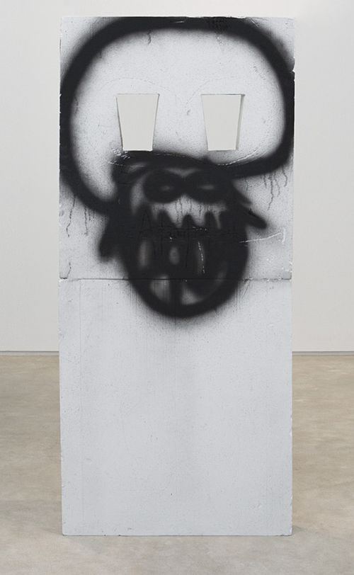 scary face with wide mouth revealing teeth spray painted in black onto white surface
