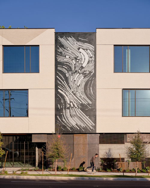 Black and white artwork on a large wall of a building