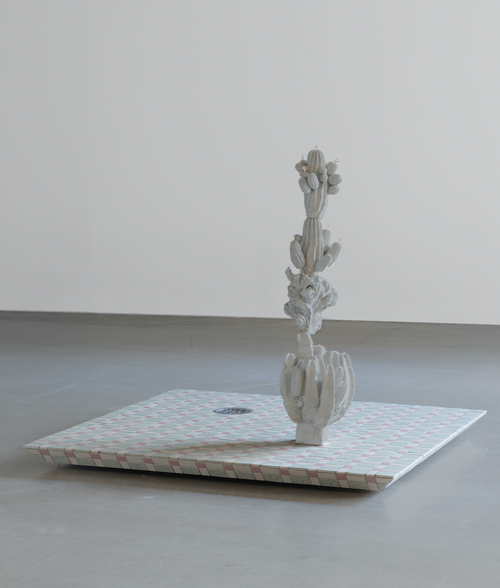 sculpture of a white cactus on a patterned rectangular surface