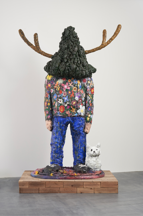 Tree Man sculpture wearing floral jumper with dog