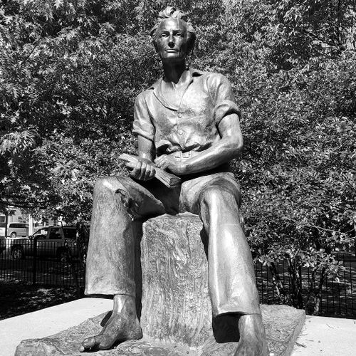 This monumental bronze shows Lincoln as a young man, perhaps in his late teens. He is seated on a tree stump, barefoot, looking up from the book he holds in his hands resting on his lap.