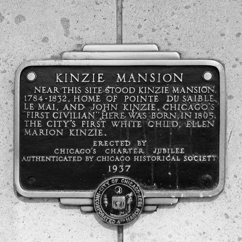 This plaque is inscribed as follows: "Kinzie Mansion. Near this site stood Kinzie Mansion, 1784-1832, Home of Pointe Du Saible, Le Mai, and John Kinzie. Chicago's "First Civilian" here was born, in 1805, the city's first white child, Ellen Marion Kinzie.- Erected by Chicago's Charter Jubilee - Authenticated by Chicago Historical Society - 1937."