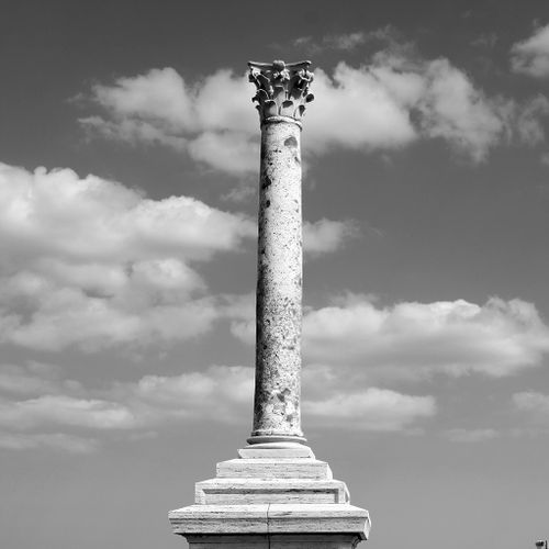 The monument to Italian air marshal Italo Balbo consists of a base with an inscription to the subject on top of which stands a slender, tapering column with an ionic capital, decorated with carved acanthus leaves.