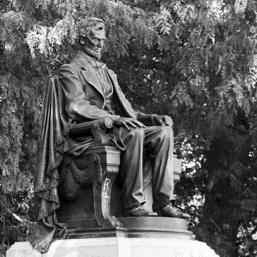 In contrast to the earlier, Standing Lincoln, this second monument by Augustus Saint-Gaudens shows Lincoln seated in the chair of state, looking even more remote, dwelling on the concerns of his office and elevated on a much higher and less approachable plinth. Both artworks, however, were framed by a large semi-circular stone bench that formed the limits of a broad platform