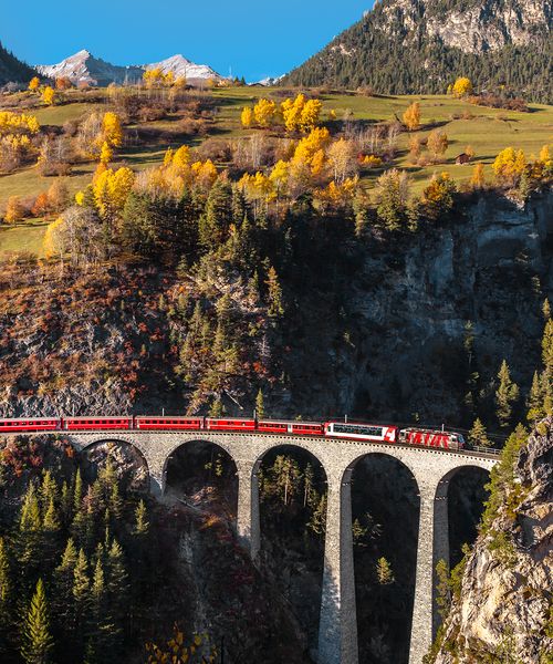 train crossing bridge in the swiss alps