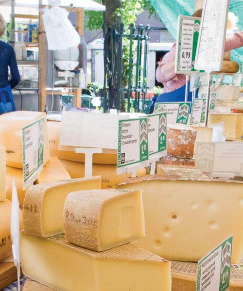 blocks of cheese stacked at outdoor market