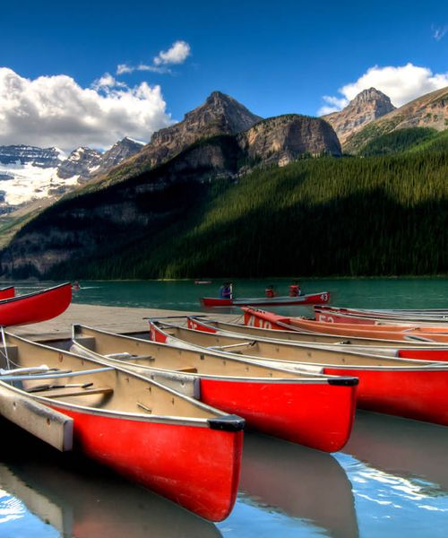 Red canoes in the blue waters of Lake Louise in Banff National Park Alberta Canada