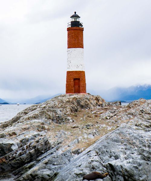 Red and white lighthouse on a rock in Ushuaia Argentina