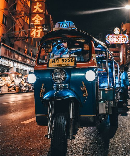 a blue rickshaw taxi at night in bangkok thailand