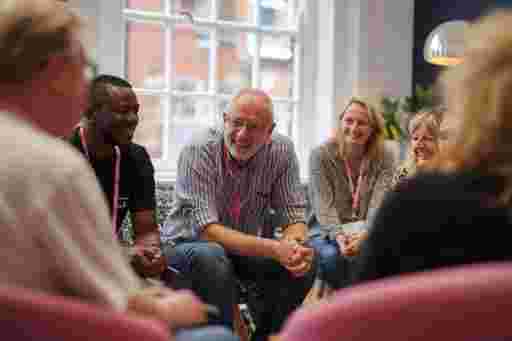Managers smiling and talking in a small group during a leadership training session